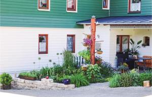 a green and white house with a garden in front of it at Awesome Apartment In Remptendorf in Gleima