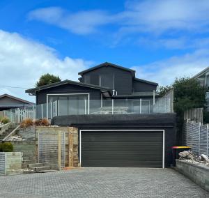 une maison avec une porte de garage devant elle dans l'établissement Best Waterfront Deck in Riverton, à Riverton