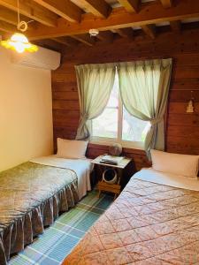 a bedroom with two beds and a window at Sanrinsha in Takamori