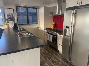 a kitchen with a stainless steel refrigerator and a sink at Best Waterfront Deck in Riverton in Riverton