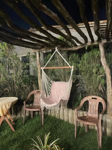 eine Hängematte im Garten mit 2 Stühlen und einem Tisch in der Unterkunft Tiny Home Garden Bananeiras in Bananeiras