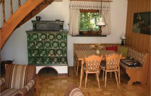 a dining room with a table and a green cabinet at 2 Bedroom Stunning Home In Lengenfeld-plohn in Pechtelsgrün
