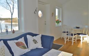 a living room with a blue couch and a window at Awesome Home In Grisslehamn With Kitchen in Grisslehamn