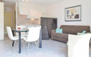 uma cozinha e sala de estar com mesa e cadeiras brancas em Residentie De Kateie Ref 15 em Oostende