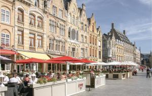 a street with tables and umbrellas in front of a building at Kapelhof in Ieper