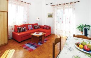ein Wohnzimmer mit einem roten Sofa und einem Tisch in der Unterkunft Awesome Apartment In Portoroz With 1 Bedrooms And Wifi in Portorož