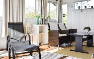 シーピンスリーにあるCozy Home In Kpingsvik With Kitchenのリビングルーム(椅子、テーブル付)