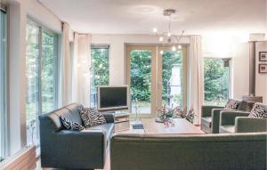 sala de estar con 2 sofás y TV en Kwikstaart, en Oudemirdum