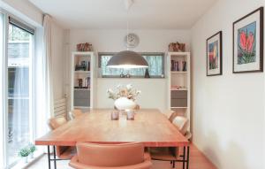 uma sala de jantar com uma mesa de madeira e cadeiras em Kwikstaart em Oudemirdum