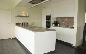 a kitchen with white cabinets and a counter top at Lieke in Poperinge