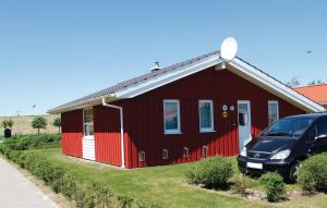 a red house with a car parked in front of it at Friedrichskoog-Strandpark 9 in Friedrichskoog