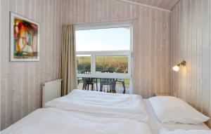 1 Schlafzimmer mit 2 Betten, einem Fenster und einem Tisch in der Unterkunft Friedrichskoog-strandpark 9 in Friedrichskoog