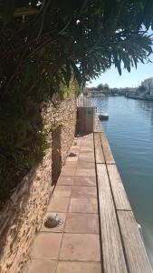 a pathway next to a body of water at Villa Empuriabrava on main canal with 13 m private mooring, private pool, air con in all rooms, non-smoking in Empuriabrava