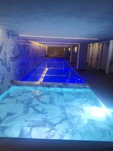 a large swimming pool with blue lights in a room at My G yoo Apartment #1 in Istanbul