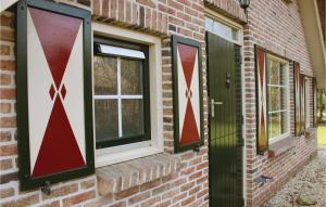 a brick house with two windows and a green door at De Haan in IJhorst