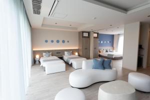 - un salon avec des meubles blancs et des chaises blanches dans l'établissement HOTEL天 -Tin-, à Ujimi