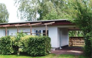 una casa blanca con garaje y algunos arbustos en 2 Bedroom Cozy Home In Trassenheide, en Trassenheide