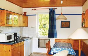 una pequeña cocina con mesa y microondas en 2 Bedroom Cozy Home In Trassenheide, en Trassenheide