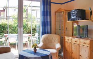 sala de estar con TV, silla y mesa en 2 Bedroom Cozy Home In Trassenheide, en Trassenheide