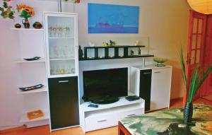 a living room with a flat screen tv and shelves at 1 Bedroom Awesome Apartment In Bastorf in Bastorf