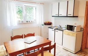 a small kitchen with a table and a microwave at 1 Bedroom Awesome Apartment In Bastorf in Bastorf +6 photos