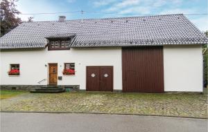 ein weißes Haus mit braunen Türen und einer Einfahrt in der Unterkunft Gorgeous Home In Monschauhöfen in Höfen