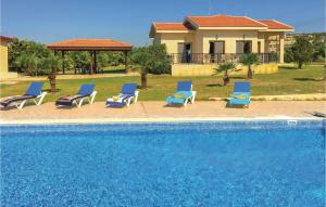 um grupo de espreguiçadeiras azuis e uma piscina em Gorgeous Home In Maroni-larnaca With Outdoor Swimming Pool em Pervolia