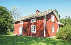 una casa roja con una sombra a su lado en Stunning Home In Lnashult With Kitchen, en Tvetaryd