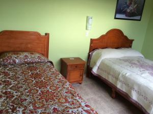 a bedroom with two beds and a night stand at Casa de Huéspedes La Rosa in Ixtapan de la Sal
