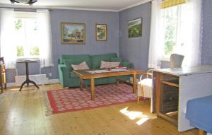 sala de estar con sofá verde y mesa en Stunning Home In Lnashult With Kitchen, en Tvetaryd