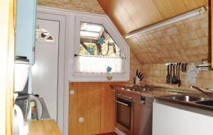 eine kleine Küche mit einem Waschbecken und einem Fenster in der Unterkunft Beautiful Home In Langelsheim With House A Mountain View in Langelsheim