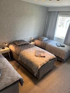 1 dormitorio con 2 camas y ventana en Kemi CITY III near snowcastle, 2 rooms , kitchen , glazed balcony, FREE private parking en Kemi