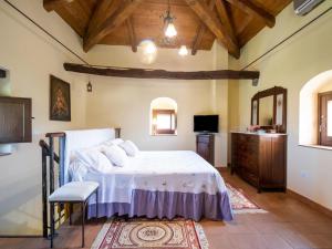 GuardavalleにあるBeautiful holiday home in Stilo with a swimming poolのベッドルーム(ベッド1台、ドレッサー、テレビ付)