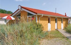 una pequeña casa amarilla con techo rojo en Schatzkiste 1 - Dorf 4 en Travemünde