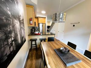 a kitchen and dining room with a wooden table and chairs at Renovated Chalet at Mystic Springs, Pool, Hot Tub! in Canmore