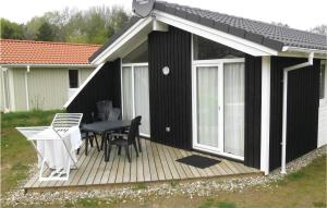 a black and white deck with a table and chairs at Dnenpark 2c - Dorf 4 in Travemünde