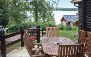 een houten tafel en stoelen op een terras met een meer bij Stunning Home In Kvicksund With House Sea View in Kvicksund