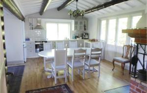 Stunning Home In Kvicksund With House Sea View في Kvicksund: مطبخ فيه طاولة بيضاء وكراسي