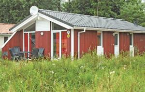 ein rotes Gebäude mit Stühlen auf einem Grasfeld in der Unterkunft Freibeuterweg 18 - Dorf 5 in Travemünde