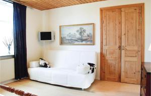 ein Wohnzimmer mit einer weißen Couch und einer Holztür in der Unterkunft Amazing Apartment In Ystad With Kitchen in Ystad
