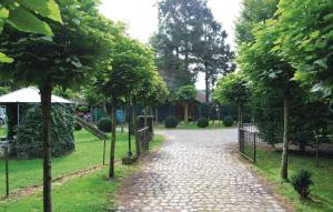 a cobblestone path in a park with trees and a fence at Sjapoo in Wachtebeke