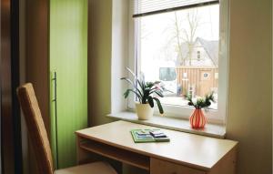 Zimmer mit einem Tisch und einem Fenster mit Pflanzen in der Unterkunft 1 Bedroom Pet Friendly Apartment In Brgerende in Börgerende-Rethwisch