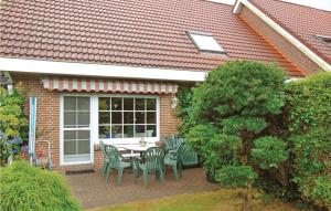 a patio with a table and chairs in front of a house at Lovely Home In Wittmund-altfunnixsiel With Kitchen in Altfunnixsiel