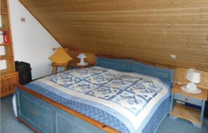 - une chambre avec un lit bleu et un plafond en bois dans l'établissement Lovely Home In Wittmund-altfunnixsiel With Kitchen, à Altfunnixsiel