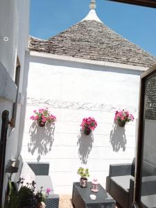 un patio con piante in vaso su una parete bianca di "B&B La Lanterna" Trulli & Dimore Storiche ad Alberobello