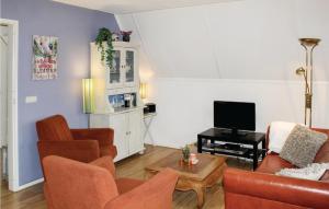 sala de estar con sofá y TV en Bungalow 189, en Den Oever
