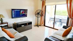 a living room with a couch and a flat screen tv at Villa Olivia in Coral Bay