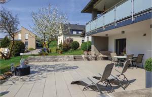 eine Terrasse mit Stühlen und einem Tisch in einem Haus in der Unterkunft Cozy Apartment In Krperich-obersgegen With Wifi in Körperich