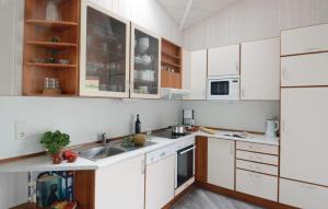 eine Küche mit weißen Schränken und einem Waschbecken in der Unterkunft Freibeuterweg 8 - Dorf 6 in Travemünde