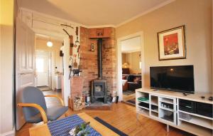un salon avec une cheminée et une télévision dans l'établissement 2 Bedroom Awesome Home In Hultsfred, à Hultsfred